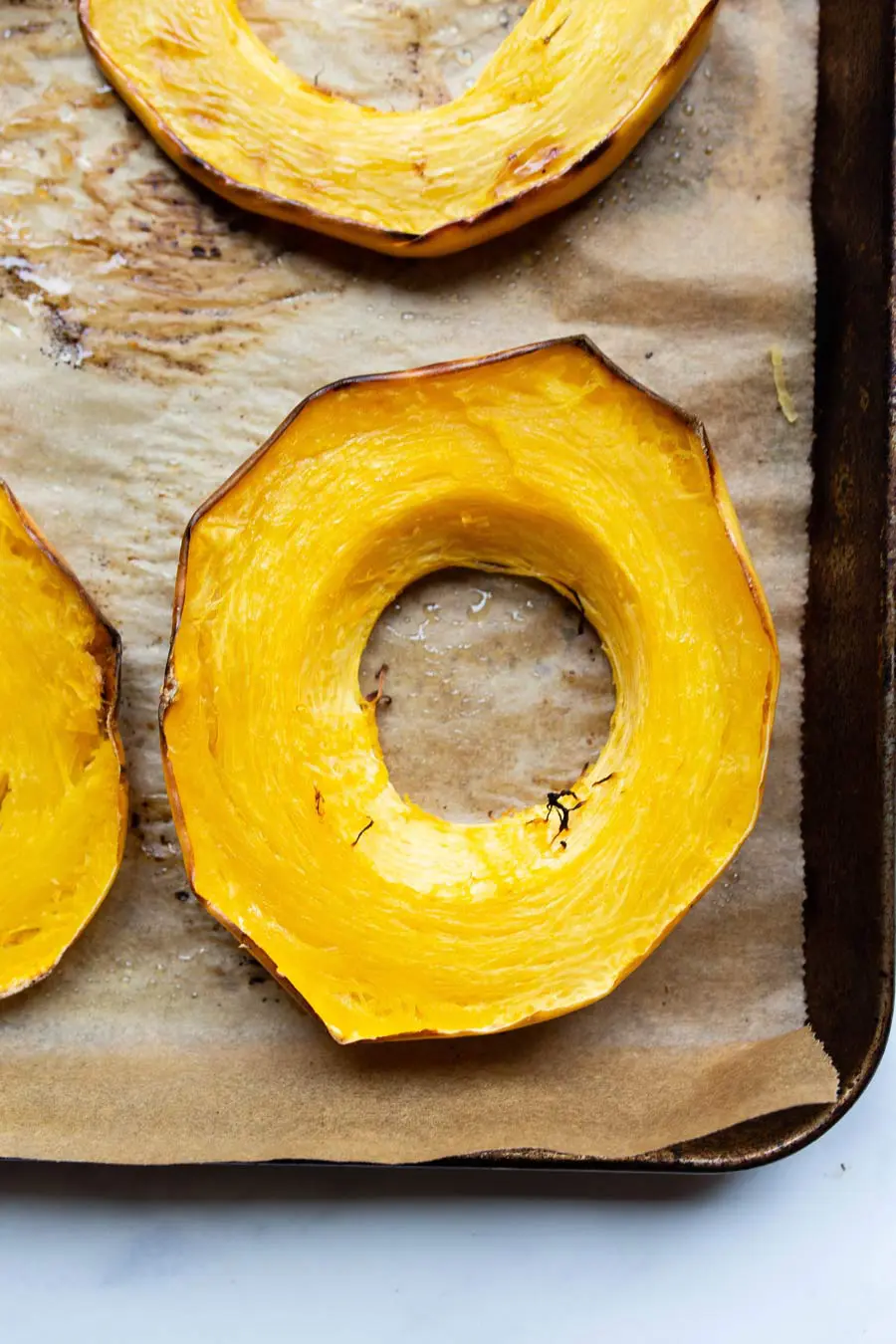 roasted spaghetti squash rings on a parchment lined baking sheet