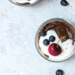 chocolate avocado pudding with whipped coconut cream and berries