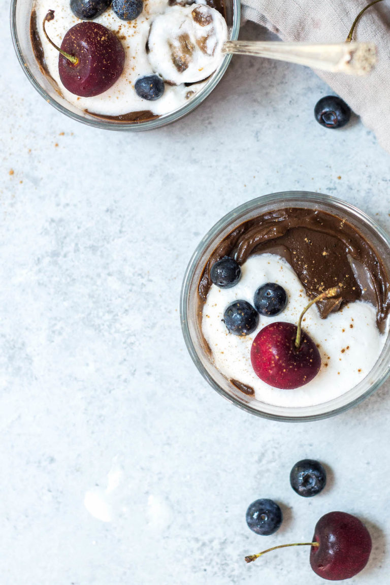 chocolate avocado pudding with whipped coconut cream and berries