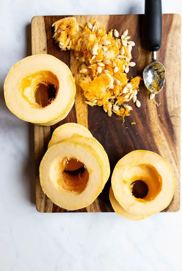 sliced spaghetti squash into rings on a cutting board with seeds taken out