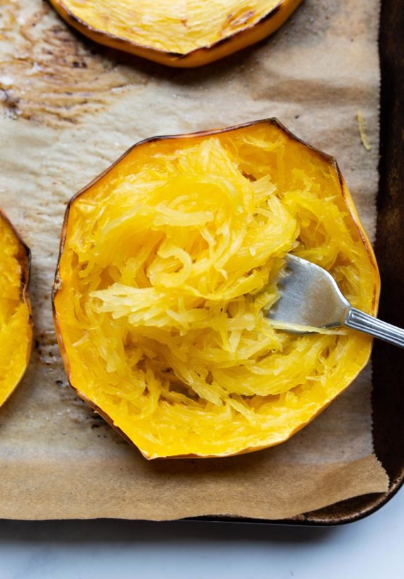 spaghetti squash roasted in "rings" with a fork removing the spaghetti strands
