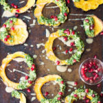 Overhead shot of rings of squash with kale and pomegranate seeds