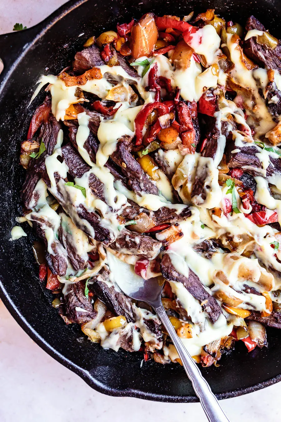 Closeup image of 30-Minute Philly Cheesesteak Skillet still in the pan. It looks like it is covered in cheese sauce, although it contains no cheese! A great gluten-free dairy-free dinner option.