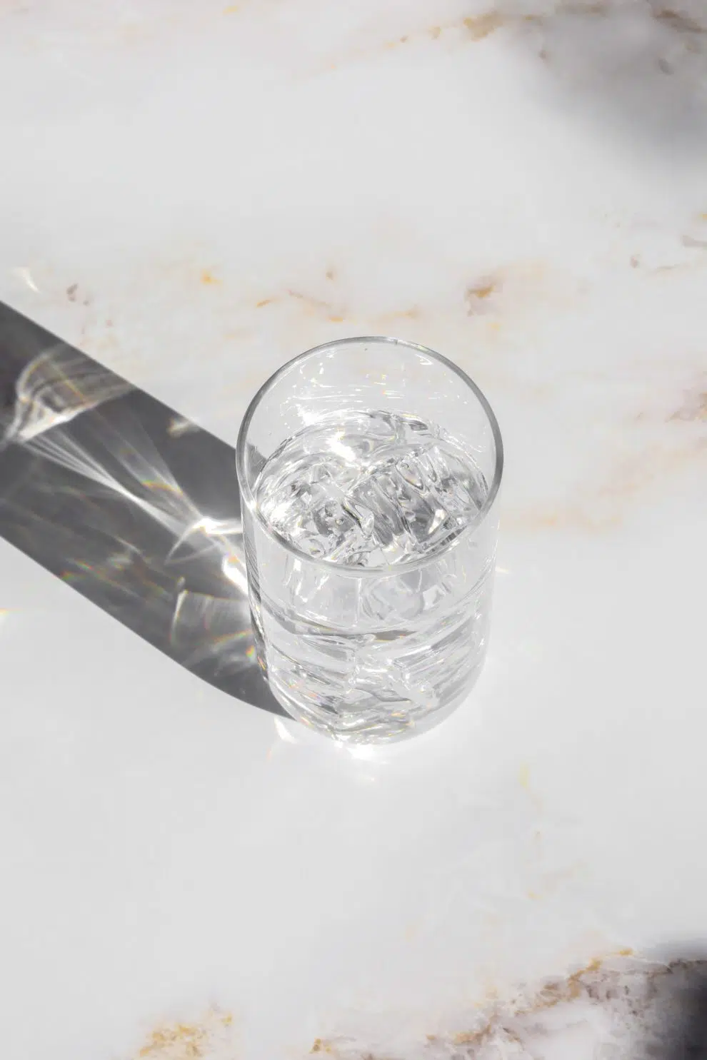 water glass with shadow on marble countertop