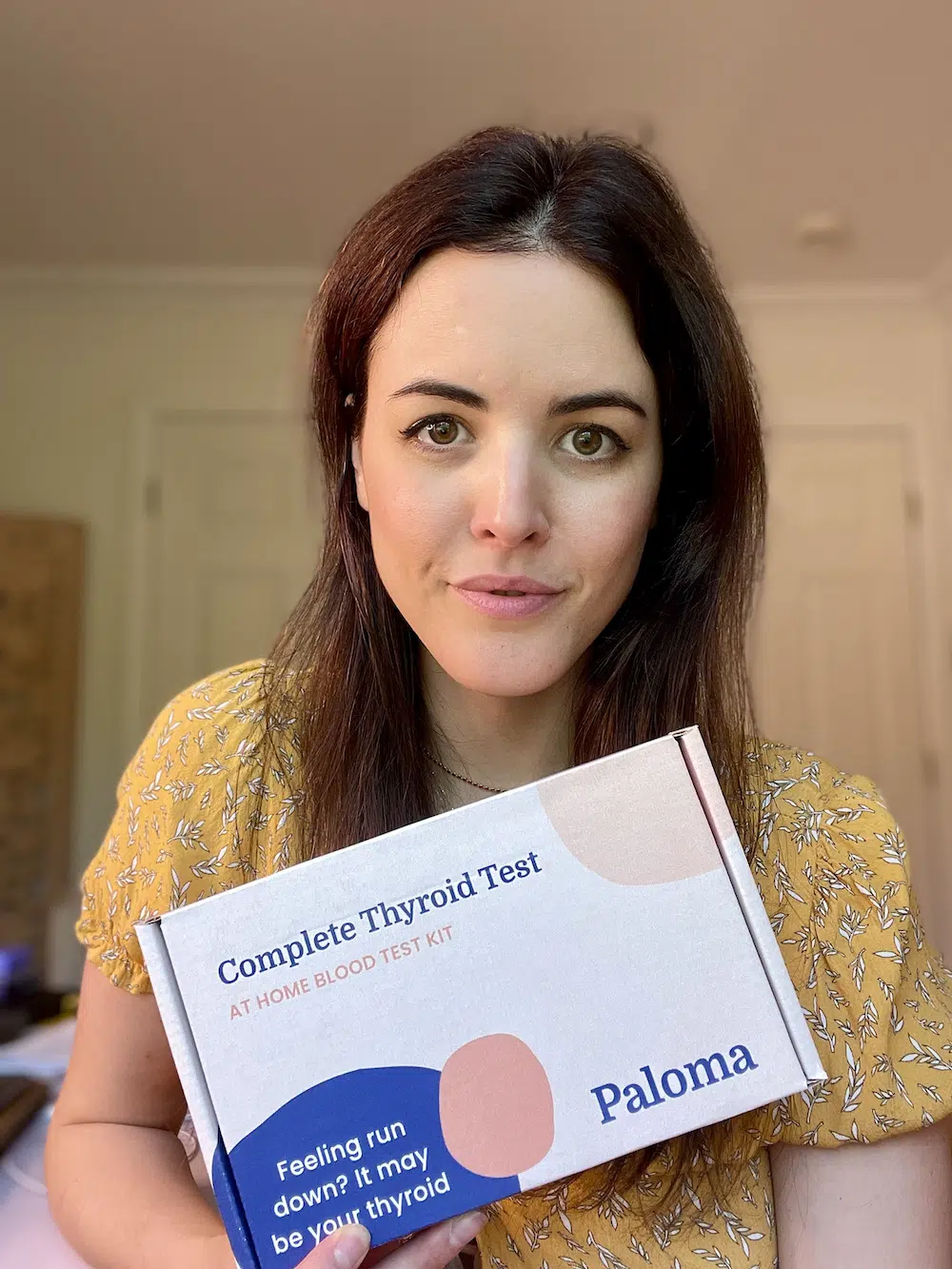 woman holding a Paloma thyroid test kit