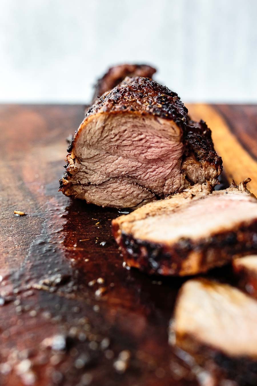 sliced balsamic pork tenderloin on cutting board