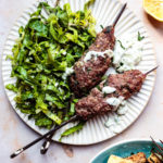 baked greek kofta kebabs with green salad and tzatziki on a plate