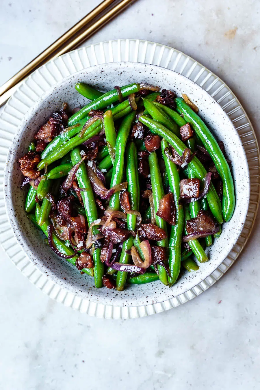 this warm green beans salad with bacon in a white serving bowl