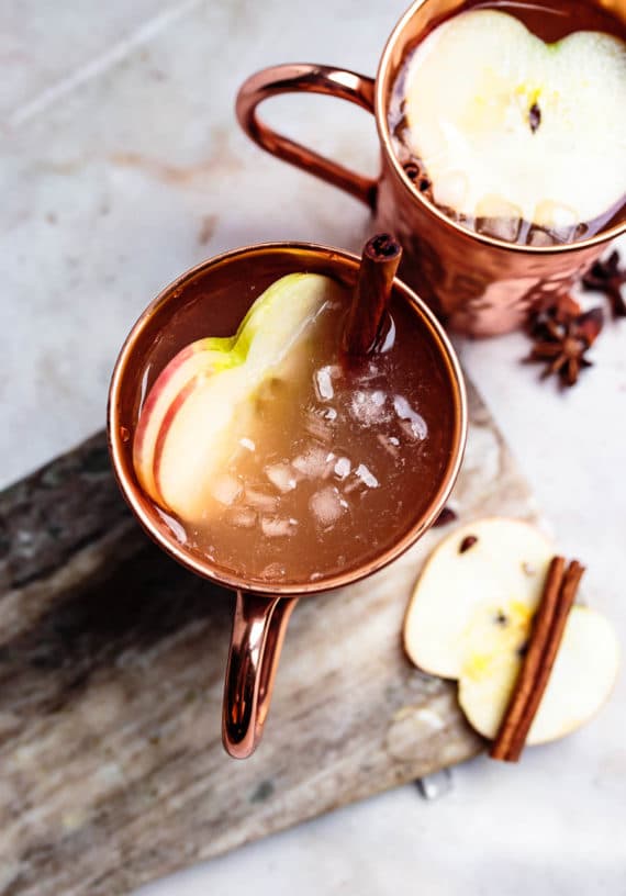 ginger apple cider mocktail with cinnamon sticks and ice