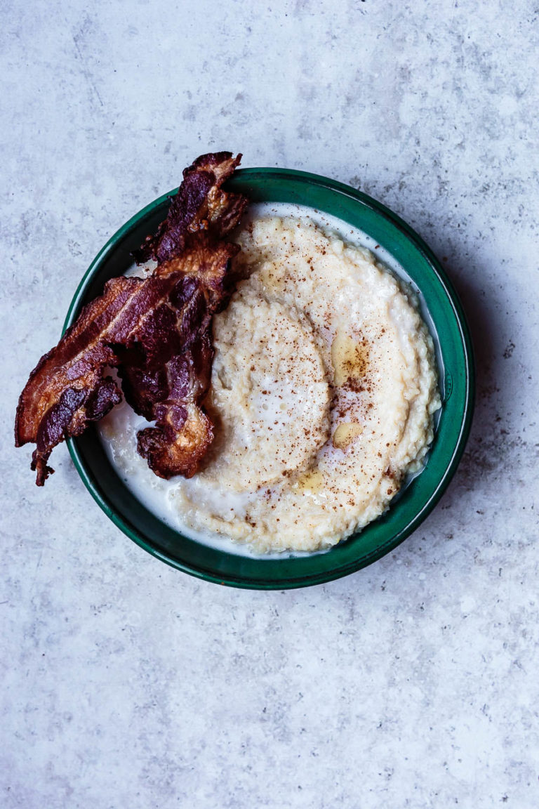 overhead shot of parsnip porridge in a circular bowl with a side of bacon