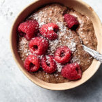 blended chocolate chia pudding with raspberries in a bowl