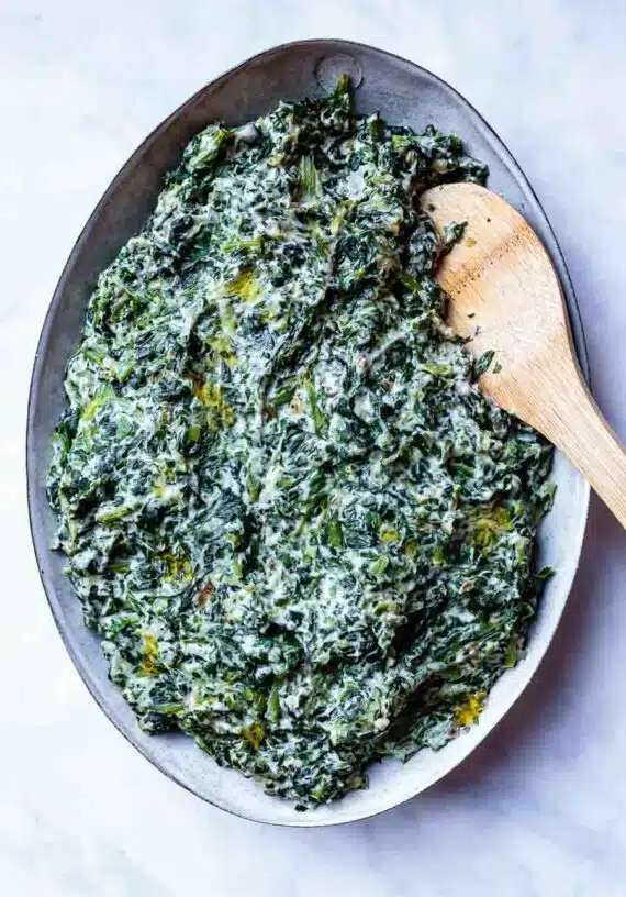 dairy free creamed spinach in a serving bowl and spoon