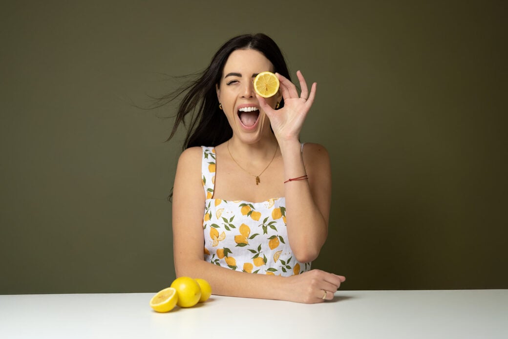 woman holding a lemon and laughing